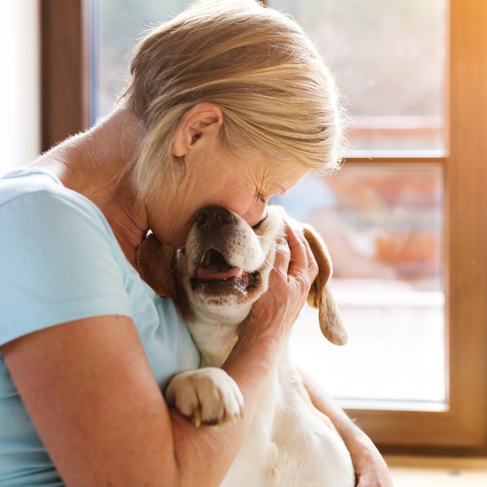 a woman hugs her dog